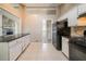 Kitchen with white cabinets, black appliances, and a view into the living room at 2132 Sara Ashley Way, Lithonia, GA 30058