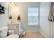 Well-lit bathroom featuring a toilet, sink, and decorative towel rack at 2513 Ivey Crest Cir, Tucker, GA 30084