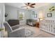 Bright bedroom with a crib, a rocking chair, and a ceiling fan at 2513 Ivey Crest Cir, Tucker, GA 30084