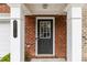 Inviting entryway featuring a classic black door, brick accents, and white trim at 2513 Ivey Crest Cir, Tucker, GA 30084