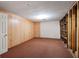 Finished basement with carpet, wood paneling, door, and built-in shelving unit at 620 Shannon Green Sw Cir, Mableton, GA 30126