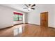 Bright bedroom featuring hardwood floors, window with red valance, and ceiling fan at 620 Shannon Green Sw Cir, Mableton, GA 30126