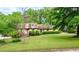 Charming brick home with manicured lawn and mature trees, providing shade and curb appeal at 620 Shannon Green Sw Cir, Mableton, GA 30126