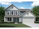 Charming two-story home featuring light blue siding, white trim, and a well-manicured lawn at 72 Warrior Ct, Braselton, GA 30548