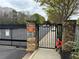 A community gate with brick columns, metal fencing, and signage indicating private property at 130 Arizona Ne Ave # 309, Atlanta, GA 30307