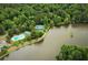 Aerial view of a community pool, tennis courts, and lush green trees near the water at 130 Floss Flower Ct, Roswell, GA 30076