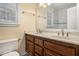 Bathroom featuring double sinks, wood cabinets, and tiled floors at 130 Floss Flower Ct, Roswell, GA 30076