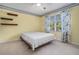 Bedroom with yellow walls, white carpet, and a bed by the window at 130 Floss Flower Ct, Roswell, GA 30076