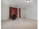 Bonus room with neutral carpet, white walls, and natural light from a window with rust-colored curtains at 130 Floss Flower Ct, Roswell, GA 30076