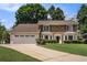 Charming brick home featuring a two-car garage, manicured lawn, and traditional design elements at 130 Floss Flower Ct, Roswell, GA 30076