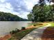 Picturesque lake view with a paved walking path along the shoreline, surrounded by lush greenery and calm waters at 130 Floss Flower Ct, Roswell, GA 30076