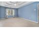 A spacious primary bedroom features a tray ceiling, ceiling fan, and a window with patterned curtains at 130 Floss Flower Ct, Roswell, GA 30076