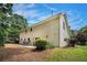 The rear exterior view showcases the home's architecture and the patio surrounded by mature trees and landscaping at 130 Floss Flower Ct, Roswell, GA 30076