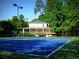 Community tennis courts beside a clubhouse and mature trees, perfect for a relaxing game in a scenic setting at 130 Floss Flower Ct, Roswell, GA 30076