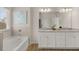 Neutral bathroom featuring double vanity sinks, a tub, and a separate shower at 219 Whispering Pines Ave, Conyers, GA 30094