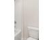 Bright bathroom featuring a modern toilet and tub with a shower combination at 219 Whispering Pines Ave, Conyers, GA 30094