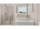 Bathroom features a glass shower and a tub beneath a bright window allowing for a refreshing bathing experience at 219 Whispering Pines Ave, Conyers, GA 30094