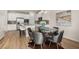 Open-concept kitchen and dining area with stainless steel appliances, seating for six, and hardwood flooring at 219 Whispering Pines Ave, Conyers, GA 30094