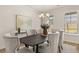 Stylish dining room showcasing a dark wood table, upholstered chairs, modern chandelier, and bright windows at 219 Whispering Pines Ave, Conyers, GA 30094