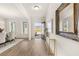Bright and airy foyer with hardwood floors, console table, and artwork creating a welcoming entrance at 219 Whispering Pines Ave, Conyers, GA 30094