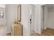 Hallway featuring wood-look flooring, a decorative mirror, and access to the adjacent bathroom at 219 Whispering Pines Ave, Conyers, GA 30094