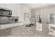 Close-up of a kitchen island with granite countertops, stainless steel sink, and modern faucet fixture at 219 Whispering Pines Ave, Conyers, GA 30094