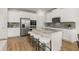 The open kitchen features white cabinets, stainless steel appliances and a large island with barstool seating at 219 Whispering Pines Ave, Conyers, GA 30094