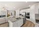 This open kitchen features white cabinets, stainless steel appliances, granite countertops and an eat-in island at 219 Whispering Pines Ave, Conyers, GA 30094