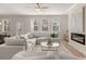 Inviting living room with modern fireplace, plenty of seating, and an open layout to the dining area at 219 Whispering Pines Ave, Conyers, GA 30094