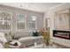 Bright living room with neutral walls, hardwood flooring, modern fireplace, and lots of natural light at 219 Whispering Pines Ave, Conyers, GA 30094