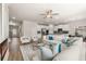 Bright, open-concept living room with hardwood floors, modern furnishings, and stainless steel kitchen appliances at 219 Whispering Pines Ave, Conyers, GA 30094