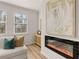 Cozy living room featuring an electric fireplace, plush seating, and natural light from the window at 219 Whispering Pines Ave, Conyers, GA 30094
