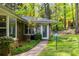 Side entrance to the property with brick facade, trimmed lawn, and a clear glass storm door at 2558 Landeau Cir, Tucker, GA 30084