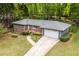 A sprawling brick ranch with an attached two car garage and beautiful yard surrounded by mature trees at 2558 Landeau Cir, Tucker, GA 30084
