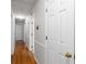Hallway featuring hardwood floors, white trim, and a glimpse of other rooms in the home at 2558 Landeau Cir, Tucker, GA 30084