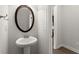 Elegant powder room featuring a pedestal sink, decorative oval mirror, and neutral paint at 7340 Jamestown Dr, Alpharetta, GA 30005