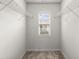 An empty walk-in closet with a window and standard wire shelving for organization at 7340 Jamestown Dr, Alpharetta, GA 30005