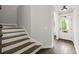 Bright foyer with hardwood floors, wooden stairs, and a white front door with glass inserts at 7340 Jamestown Dr, Alpharetta, GA 30005