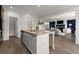 Open kitchen with large island, pantry, and view of the living room with fireplace at 7340 Jamestown Dr, Alpharetta, GA 30005