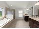 Main bathroom with dual sink vanity, soaking tub, tiled shower, and natural light at 7340 Jamestown Dr, Alpharetta, GA 30005