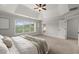 Well-lit main bedroom featuring tray ceilings, carpet floors, and a large window with backyard views at 7340 Jamestown Dr, Alpharetta, GA 30005