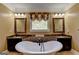 Bright bathroom featuring a soaking tub, double sink vanity with framed mirrors, and designer finishes at 2230 Cammie Wages Rd, Dacula, GA 30019
