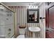 Cozy bathroom featuring vintage wallpaper, toilet, pedestal sink, and shower with gold trim at 2230 Cammie Wages Rd, Dacula, GA 30019