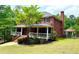 Stately two-story red brick home featuring a covered porch and a gazebo in the backyard at 2230 Cammie Wages Rd, Dacula, GA 30019