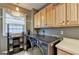 Bright laundry room with stainless steel washer and dryer, wooden cabinets and window at 2230 Cammie Wages Rd, Dacula, GA 30019