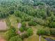 Aerial view showcasing the home nestled amongst mature trees, ponds, and greenery at 3241 Briscoe Rd, Loganville, GA 30052