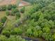 Scenic aerial view featuring the home's wooded surroundings, greenery, and nearby pond at 3241 Briscoe Rd, Loganville, GA 30052
