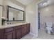 Bathroom with dual sinks, granite countertop, large vanity, and a toilet and shower behind a door at 3241 Briscoe Rd, Loganville, GA 30052