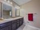 Well-lit bathroom features a double vanity with framed mirrors and tile flooring at 3241 Briscoe Rd, Loganville, GA 30052