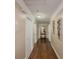 Long hallway boasts hardwood floors, neutral paint, and elegant decorative accents at 3241 Briscoe Rd, Loganville, GA 30052